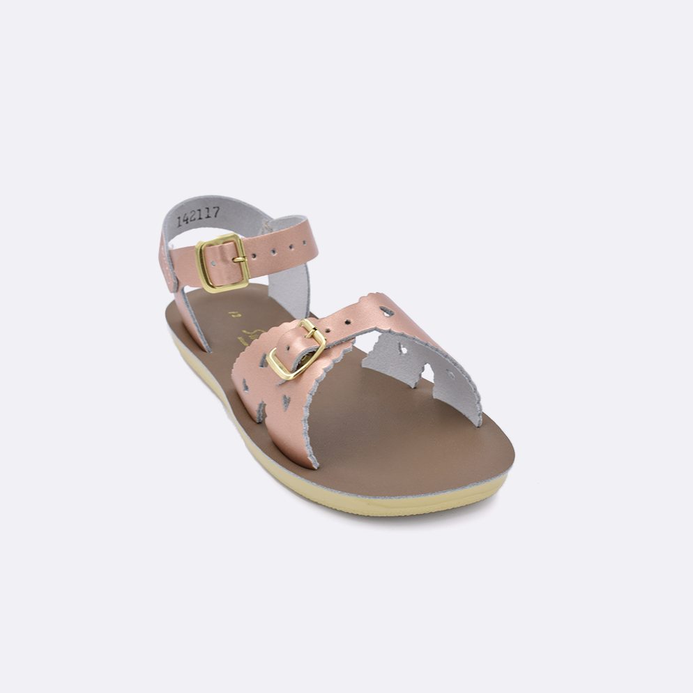 One little kid sized 1400 Sweetheart style sandal with rose gold straps and a beige insole. Facing left to right diagonally.
