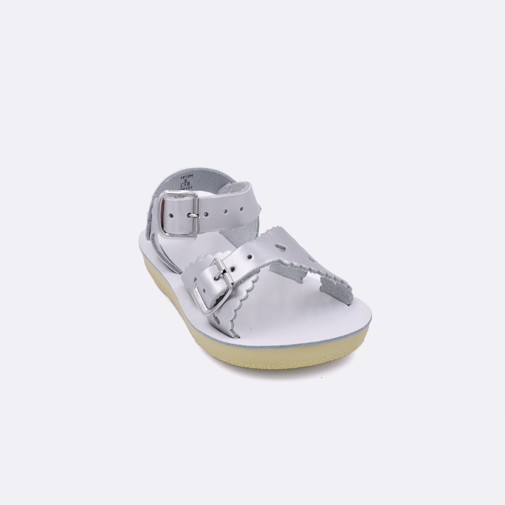 One toddler sized 1400 Sweetheart style sandal with silver straps and a white insole. Facing left to right diagonally.
