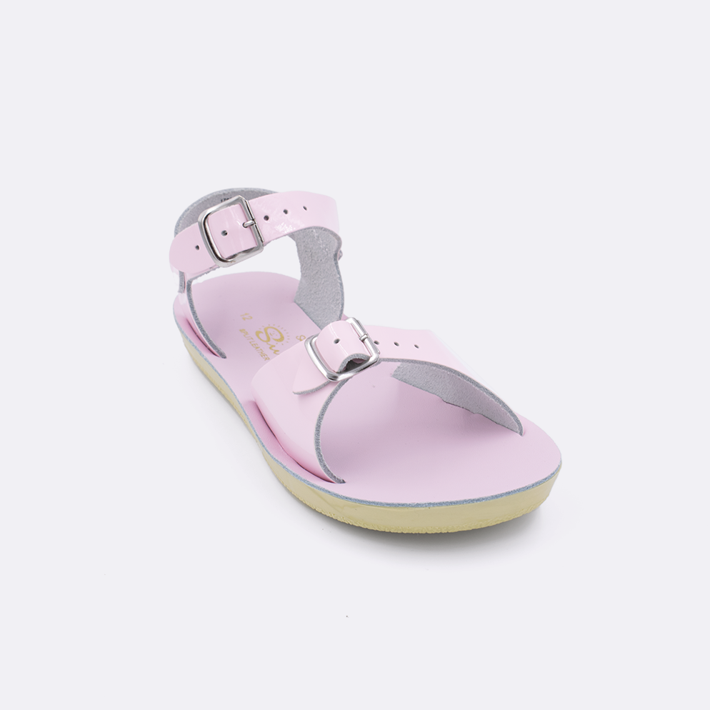 One little kid sized 1700 Surfer style sandal with shiny pink straps and a shiny pink insole. Facing left to right diagonally. 