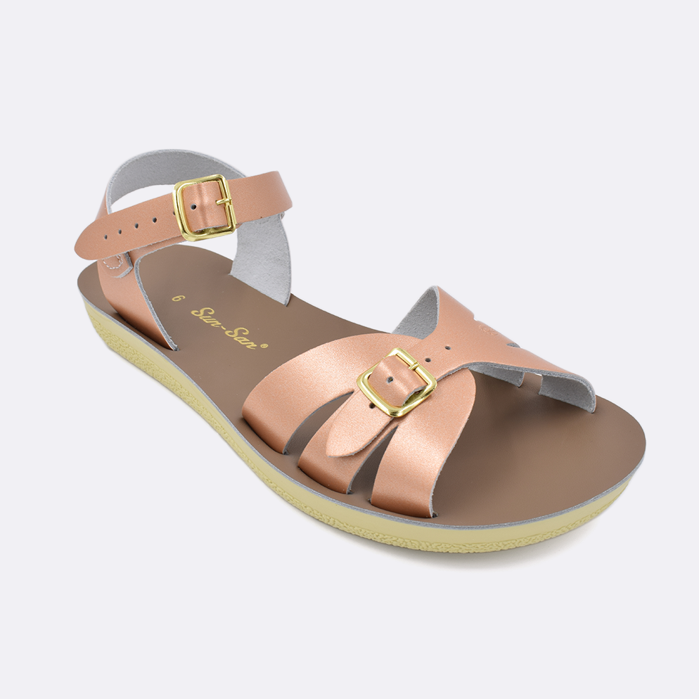 One Women's sized 1900 Boardwalk style sandal with rose gold straps and a beige insole. Facing left to right diagonally.