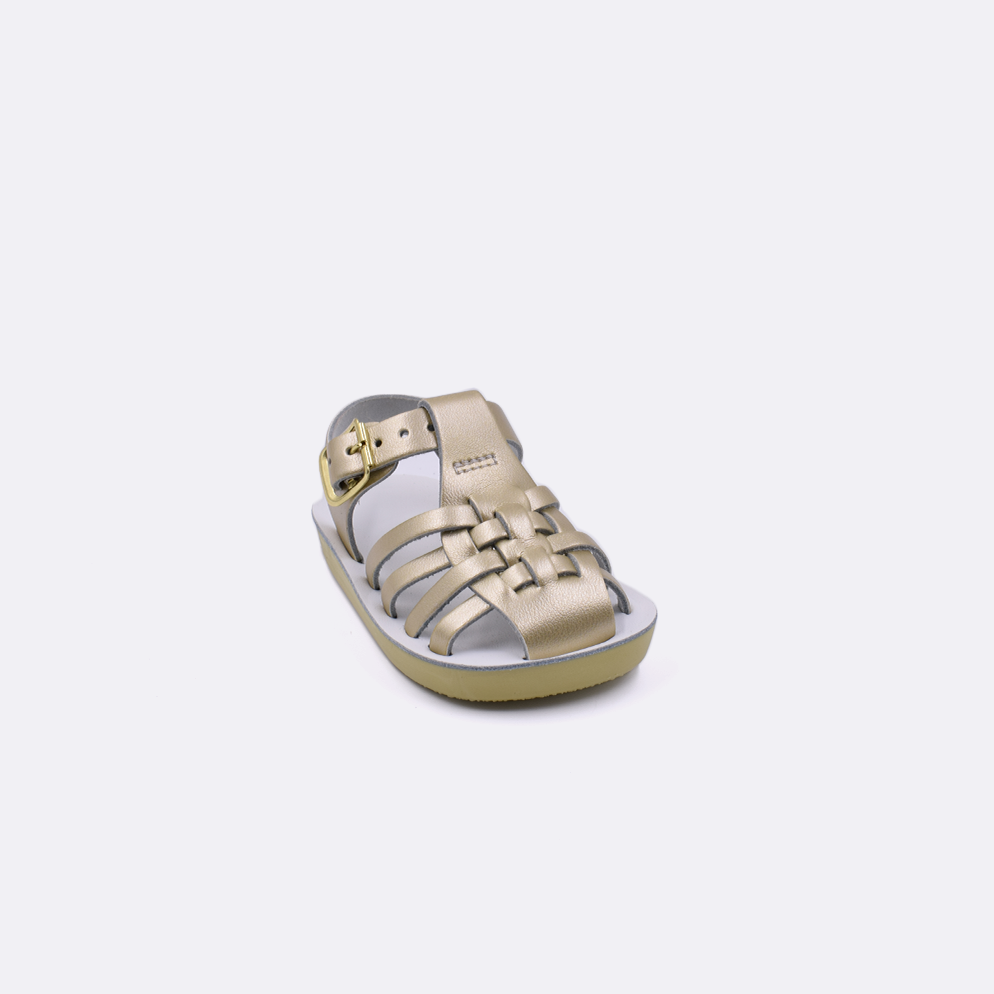 One baby sized 4200 Sailor style sandal with gold straps and a white insole. Facing left to right diagonally.