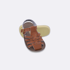 Two baby sized 4200 Sailor style sandals with tan straps and beige insoles.  One standing with the sole facing the camera. The second is laying diagonally over the top left edge of the sole.