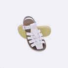 Two toddler sized 4200 Sailor style sandals with white straps and beige insoles.  One standing with the sole facing the camera. The second is laying diagonally over the top left edge of the sole.