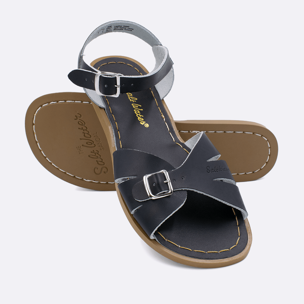 Two 900 Classic style sandals color white.  One standing with the sole facing the camera. The second is laying diagonally over the top left edge of the sole.	Adult Size.