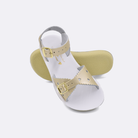 Two little kid sized 1400 Sweetheart style sandals with gold straps and white insoles.  One standing with the sole facing the camera. The second is laying diagonally over the top left edge of the sole.