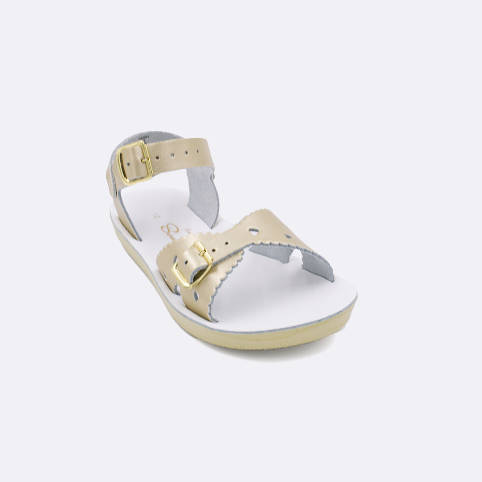 One little kid sized 1400 Sweetheart style sandal with gold straps and a white insole. Facing left to right diagonally. 