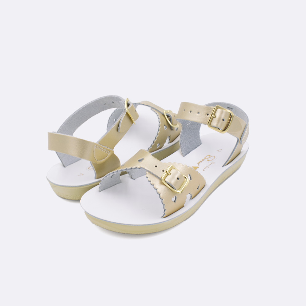 Two little kid sized 1400 Sweetheart style sandals with gold straps and white insoles. Both pushed together facing the camera diagonally.