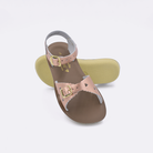 Two little kid sized 1400 Sweetheart style sandals with rose gold straps and beige insoles.  One standing with the sole facing the camera. The second is laying diagonally over the top left edge of the sole.