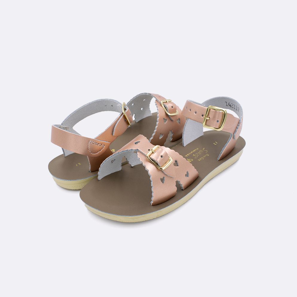 Two little kid sized 1400 Sweetheart style sandals with rose gold straps and beige insoles. Both pushed together facing the camera diagonally.