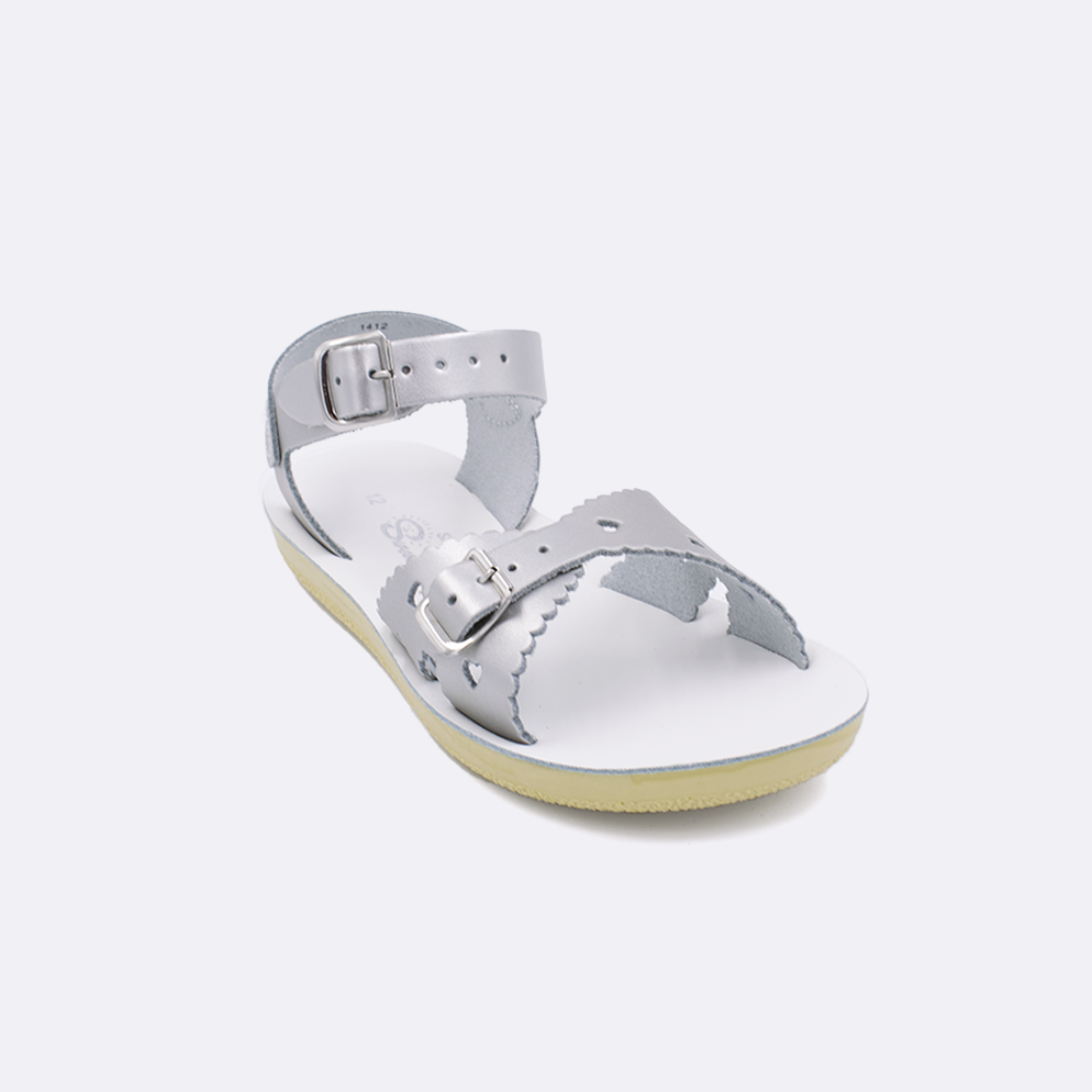 One little kid sized 1400 Sweetheart style sandal with silver straps and a white insole. Facing left to right diagonally. 