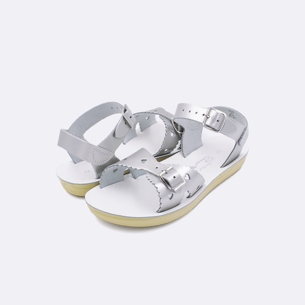 Two little kid sized 1400 Sweetheart style sandals with silver straps and white insoles. Both pushed together facing the camera diagonally.