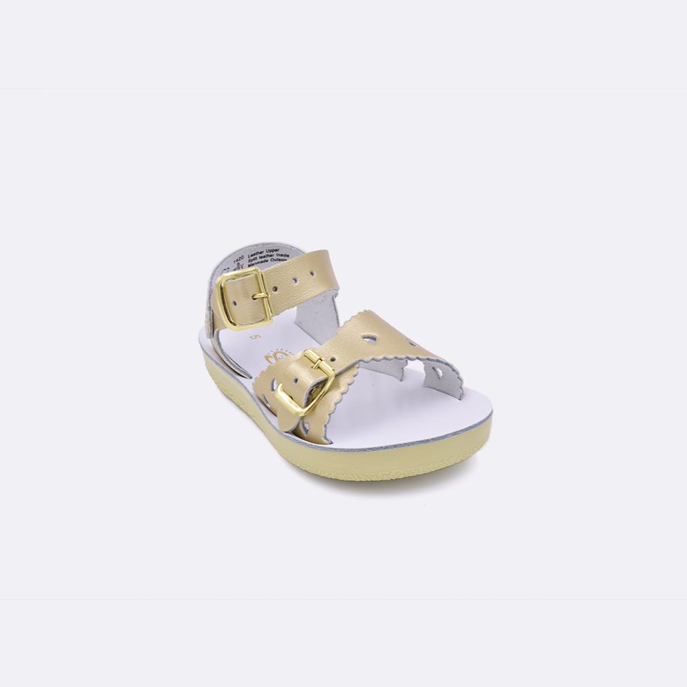 One toddler sized 1400 Sweetheart style sandal with gold straps and a white insole. Facing left to right diagonally. 