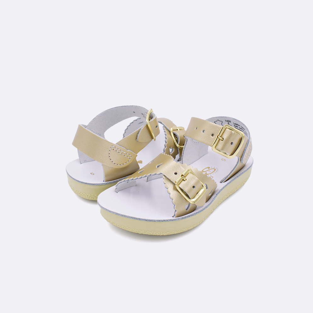 Two toddler sized 1400 Sweetheart style sandals with gold straps and white insoles. Both pushed together facing the camera diagonally.