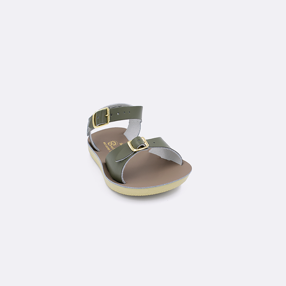 One toddler sized 1700 Surfer style sandal with olive straps and a beige insole. Facing left to right diagonally. 