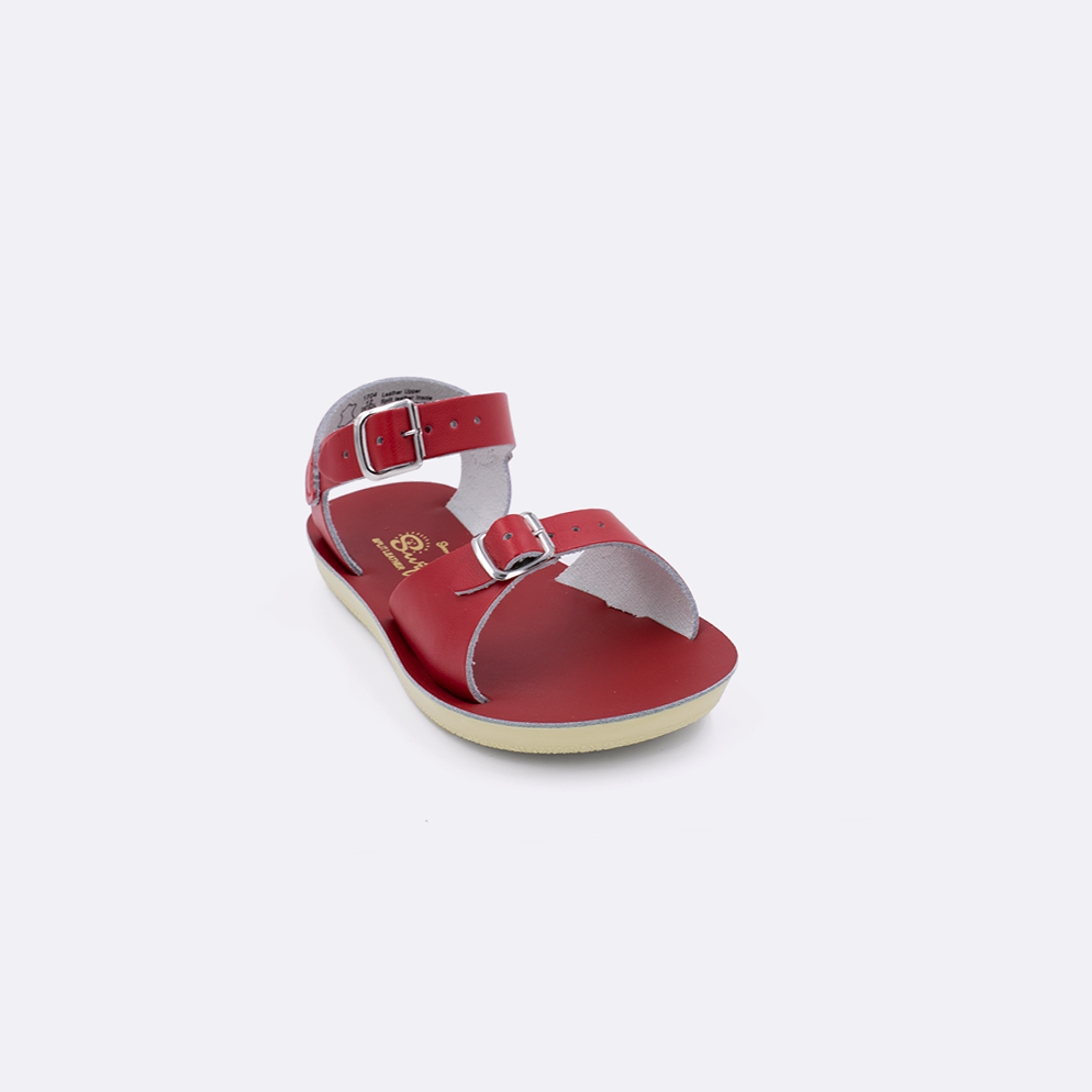 One toddler sized 1700 Surfer style sandal with red straps and a red insole. Facing left to right diagonally. 