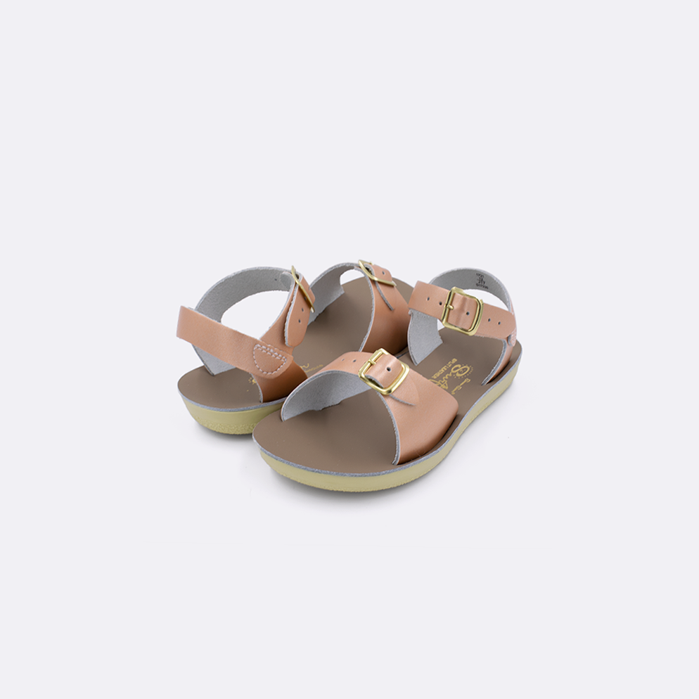 Two toddler sized 1700 Surfer style sandals with rose gold straps and beige insoles. Both pushed together facing the camera diagonally.