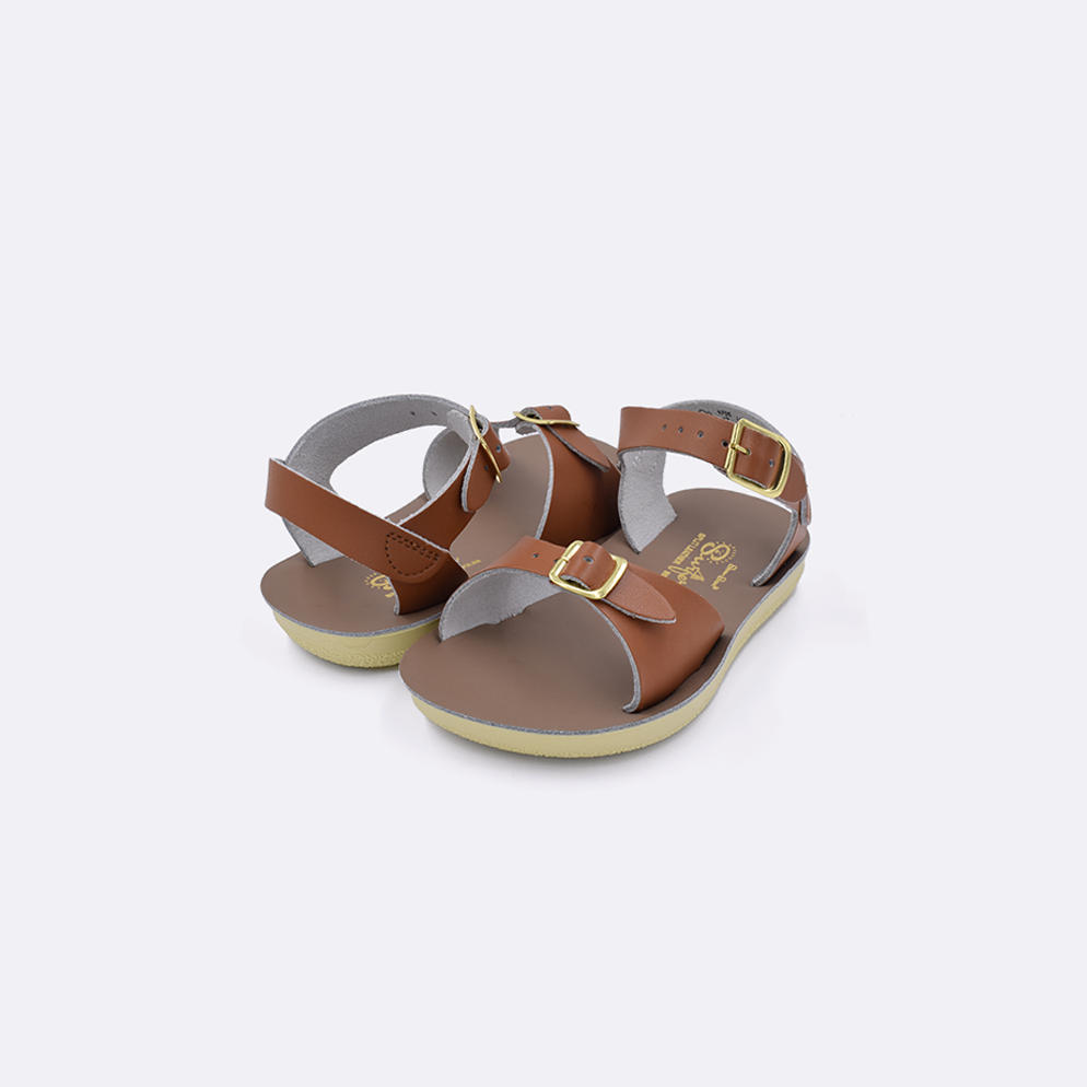Two toddler sized 1700 Surfer style sandals with tan straps and beige insoles. Both pushed together facing the camera diagonally.