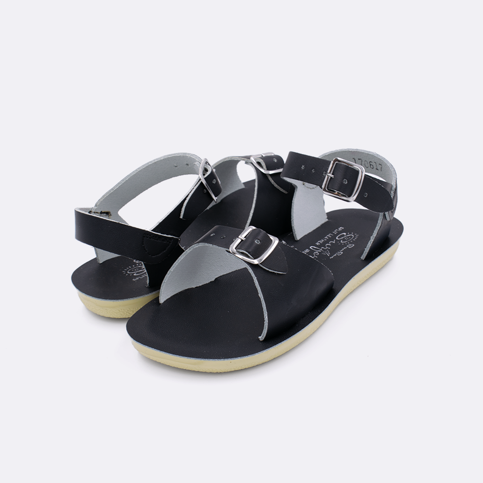 Two little kid sized 1700 Surfer style sandals with black straps and black insoles. Both pushed together facing the camera diagonally.