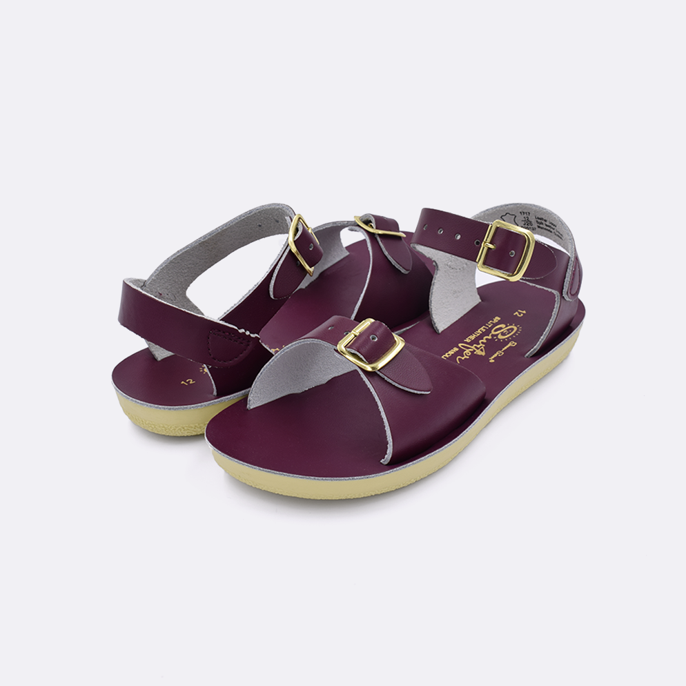 Two little kid sized 1700 Surfer style sandals with claret straps and claret insoles. Both pushed together facing the camera diagonally.