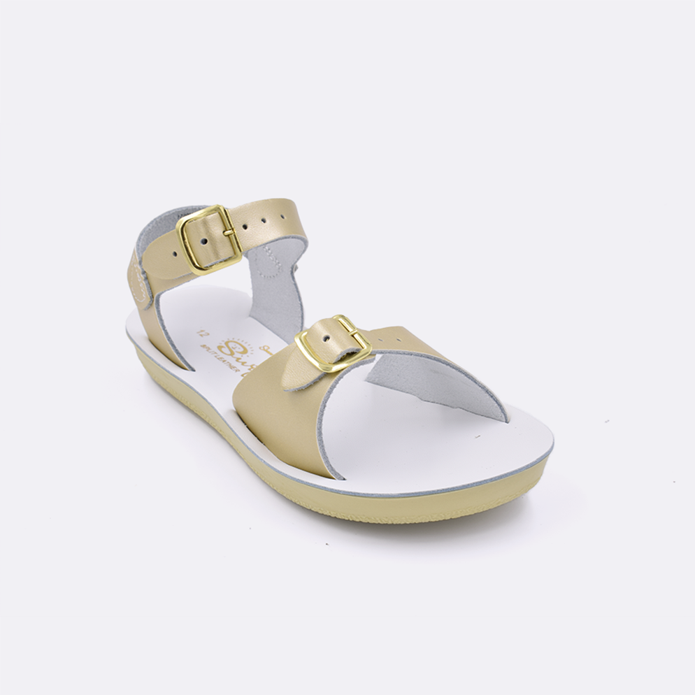 One little kid sized 1700 Surfer style sandal with gold straps and a white insole. Facing left to right diagonally. 