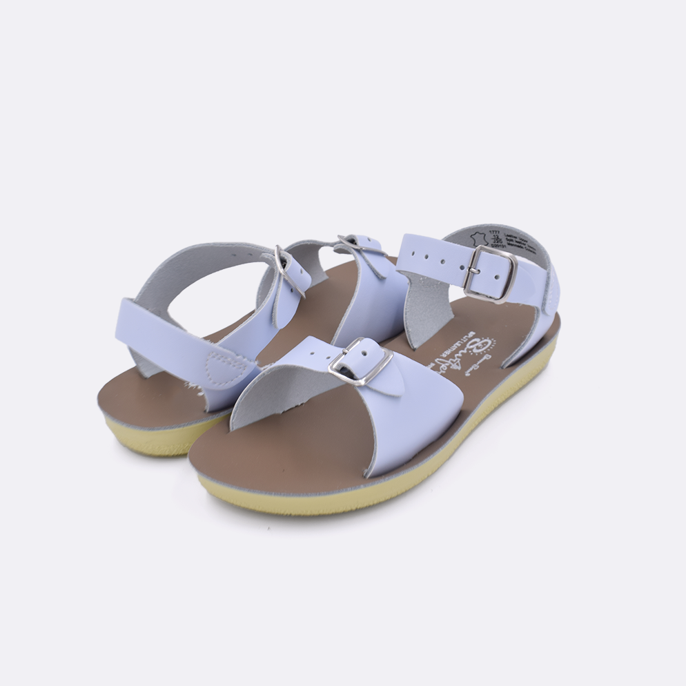 Two little kid sized 1700 Surfer style sandals with light blue straps and beige insoles. Both pushed together facing the camera diagonally.