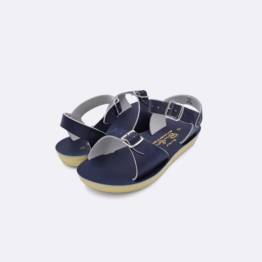 Two little kid sized 1700 Surfer style sandals with navy straps and navy insoles. Both pushed together facing the camera diagonally.