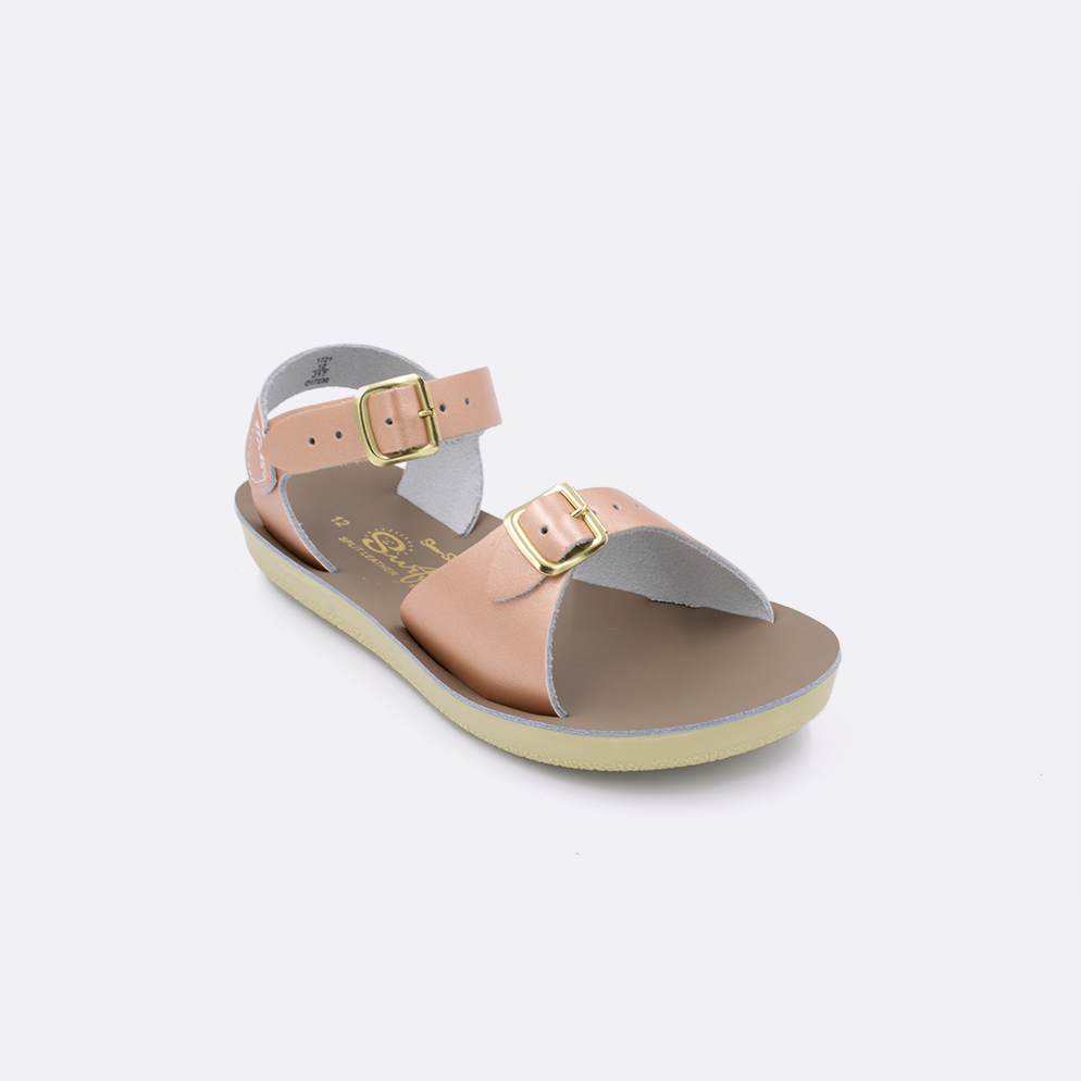 One little kid sized 1700 Surfer style sandal with rose gold straps and a beige insole. Facing left to right diagonally. 