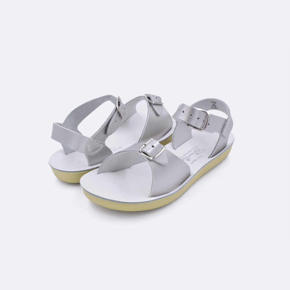 Two little kid sized 1700 Surfer style sandals with silver straps and white insoles. Both pushed together facing the camera diagonally.