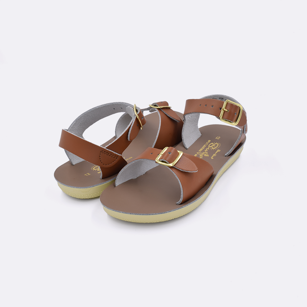 Two little kid sized 1700 Surfer style sandals with tan straps and beige insoles. Both pushed together facing the camera diagonally.