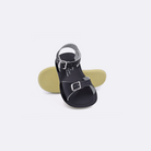Two toddler sized 1700 Surfer style sandals with black straps and black insoles.  One standing with the sole facing the camera. The second is laying diagonally over the top left edge of the sole.