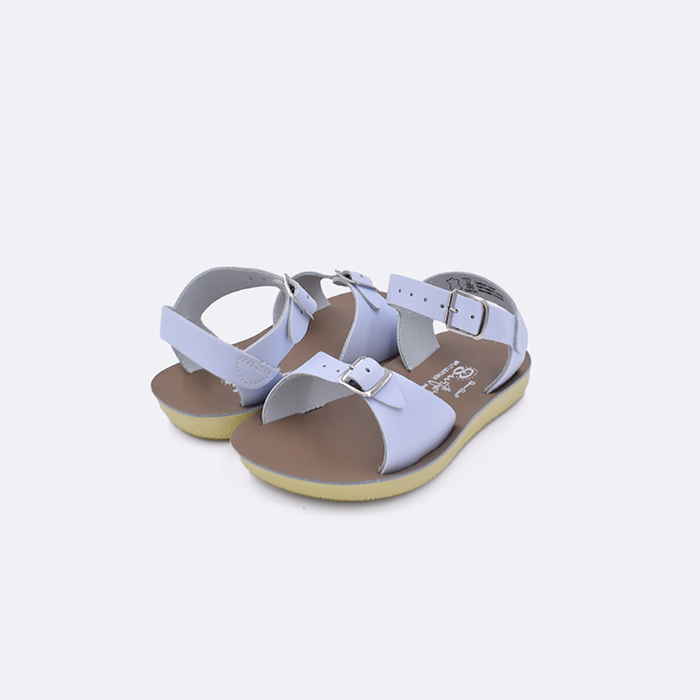 Two toddler sized 1700 Surfer style sandals with light blue straps and beige insoles. Both pushed together facing the camera diagonally.