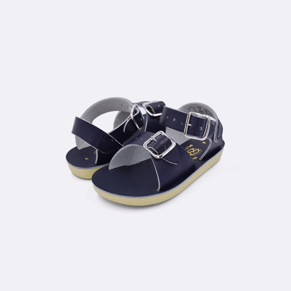 Two baby sized 1700 Surfer style sandals with navy straps and navy insoles. Both pushed together facing the camera diagonally.