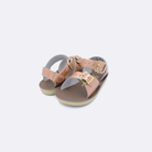 Two baby sized 1700 Surfer style sandals with rose gold straps and beige insoles. Both pushed together facing the camera diagonally.