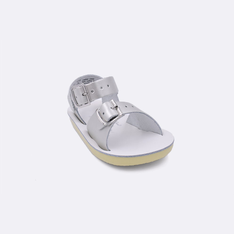 One baby sized 1700 Surfer style sandal with silver straps and a white insole. Facing left to right diagonally. 