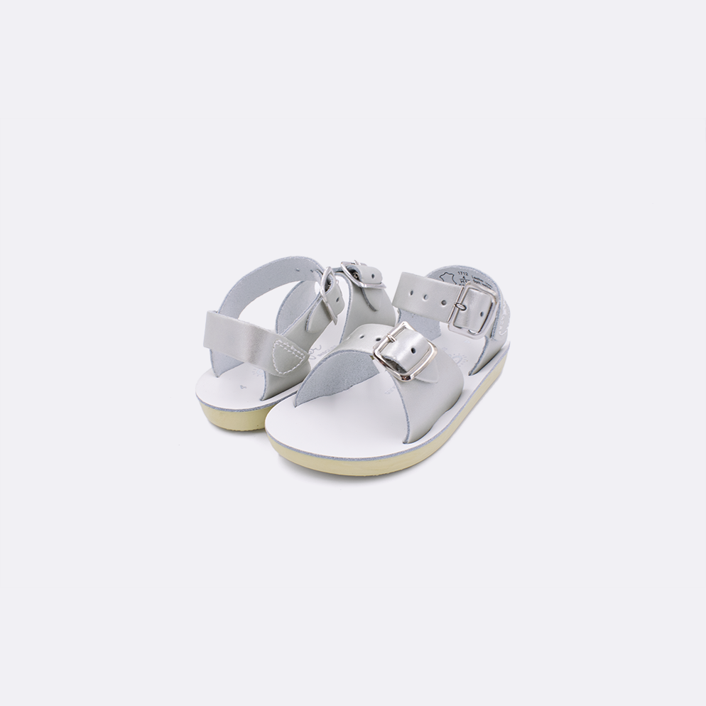 Two baby sized 1700 Surfer style sandals with silver straps and white insoles. Both pushed together facing the camera diagonally.