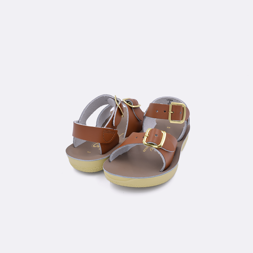 Two baby sized 1700 Surfer style sandals with tan straps and beige insoles. Both pushed together facing the camera diagonally.