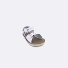 One baby sized 1700 Surfer style sandal with white straps and a beige insole. Facing left to right diagonally. 