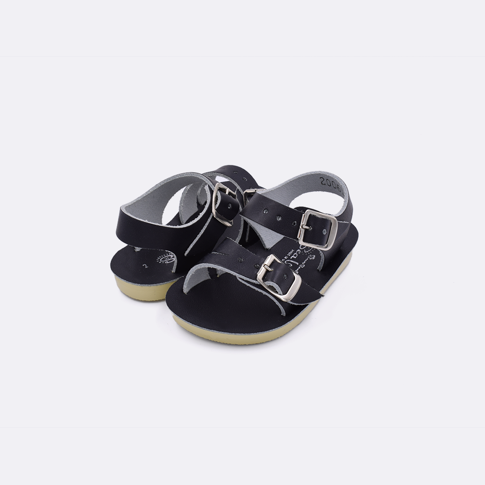 Two baby sized 2000 Sea Wee style sandals with black straps and black insoles. Both pushed together facing the camera diagonally.
