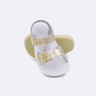 Two baby sized 2000 Sea Wee style sandals with gold straps and white insoles.  One standing with the sole facing the camera. The second is laying diagonally over the top left edge of the sole.