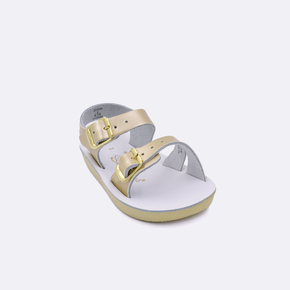 One baby sized 2000 Sea Wee style sandal with gold straps and a white insole. Facing left to right diagonally. 