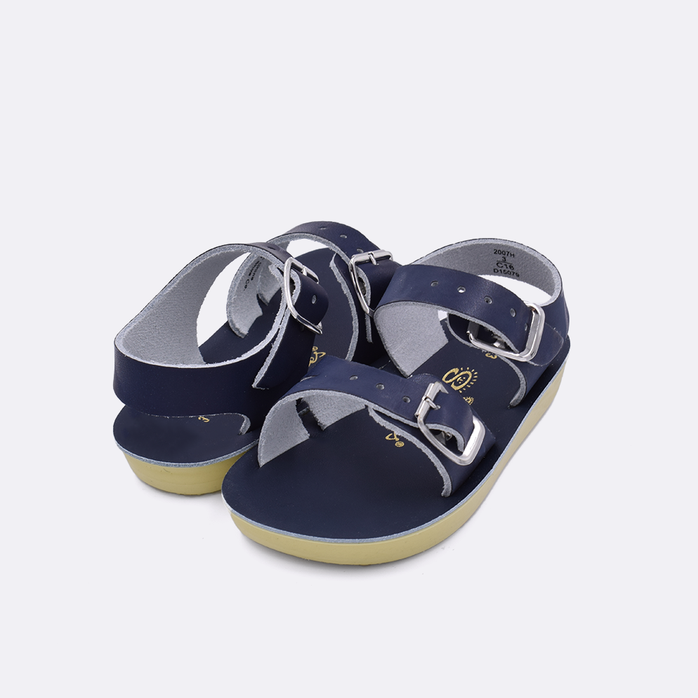 Two baby sized 2000 Sea Wee style sandals with navy straps and navy insoles. Both pushed together facing the camera diagonally.
