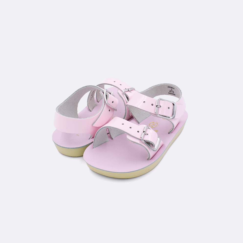 Two baby sized 2000 Sea Wee style sandals with shiny pink straps and shiny pink insoles. Both pushed together facing the camera diagonally.