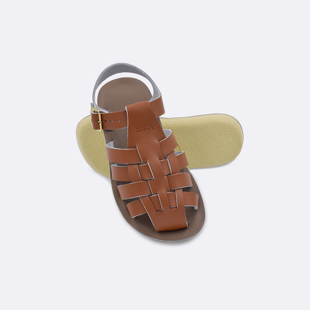 Two toddler sized 4200 Sailor style sandals with tan straps and beige insoles.  One standing with the sole facing the camera. The second is laying diagonally over the top left edge of the sole.