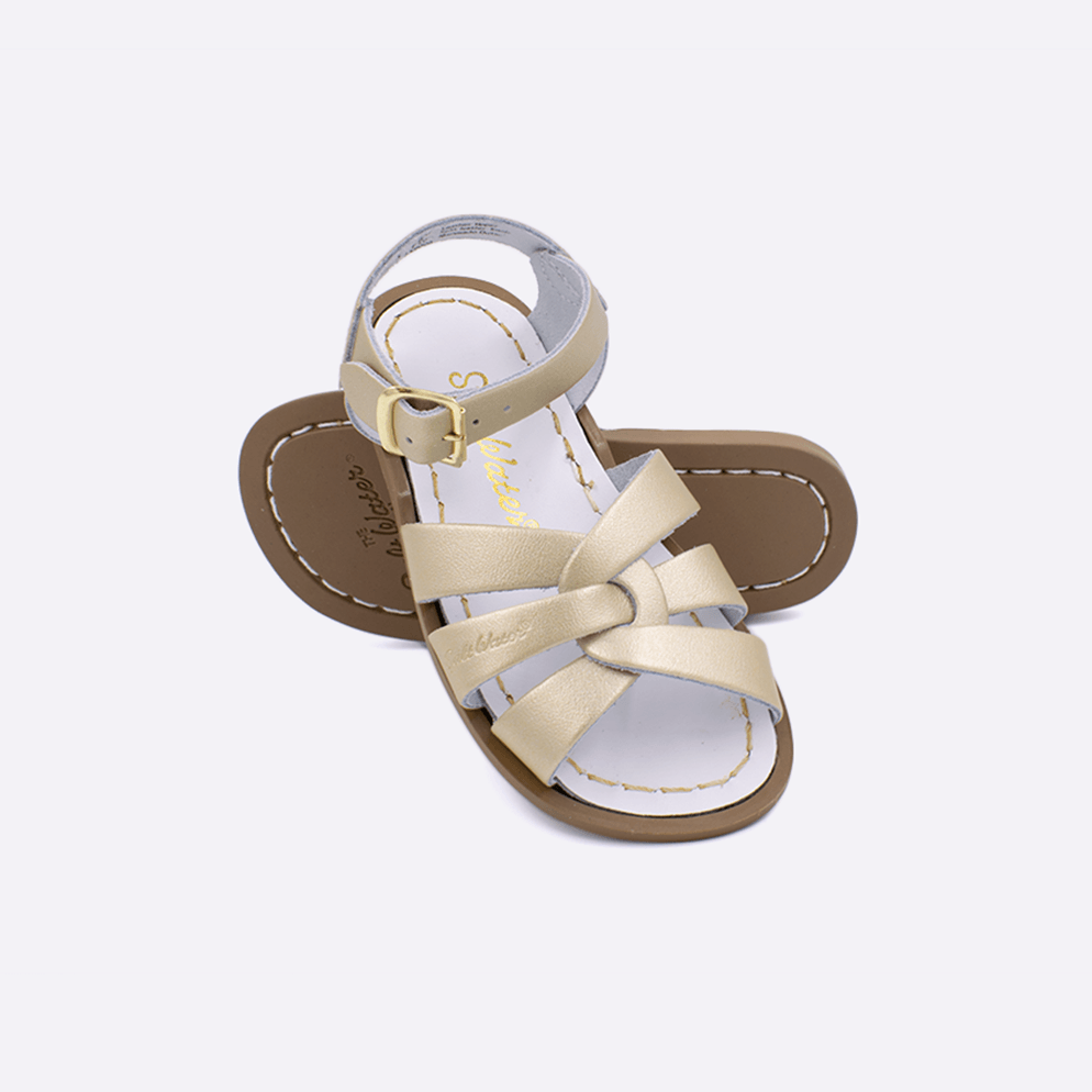 Two toddler sized 800 Original style sandals with gold straps and white insoles.  One standing with the sole facing the camera. The second is laying diagonally over the top left edge of the sole.