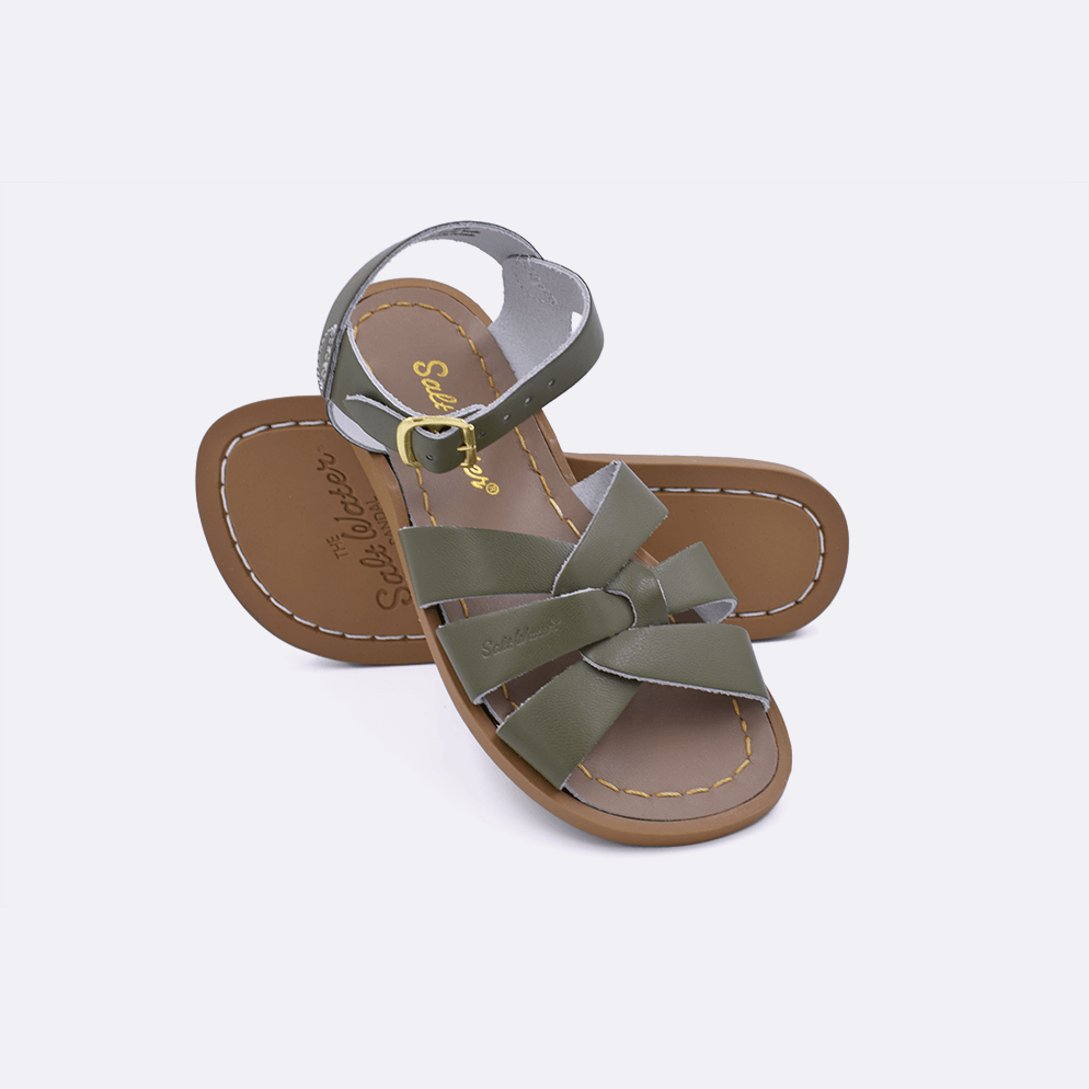 Two olive little kid sized 800 Original style sandals.  One standing with the sole facing the camera. The second is laying diagonally over the top left edge of the sole.