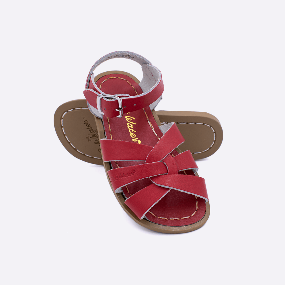 Two toddler sized 800 Original style sandals with red straps and red insoles.  One standing with the sole facing the camera. The second is laying diagonally over the top left edge of the sole.