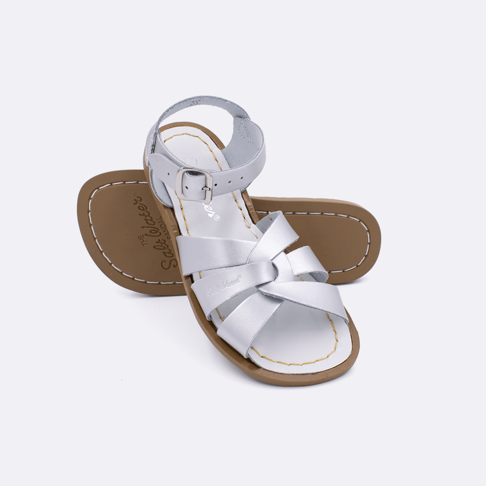 Two silver little kid sized 800 Original style sandals.  One standing with the sole facing the camera. The second is laying diagonally over the top left edge of the sole.