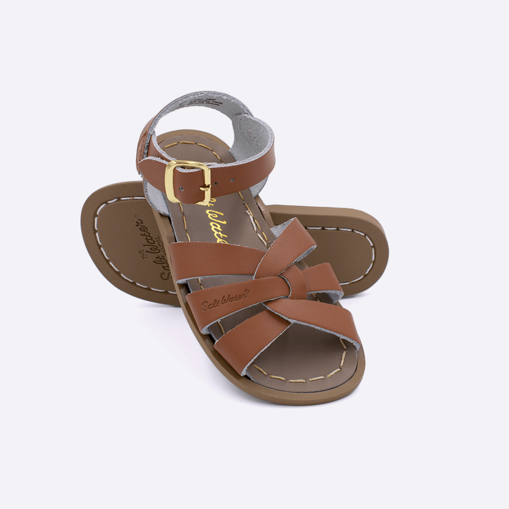 Two toddler sized 800 Original style sandals with tan straps and beige insoles.  One standing with the sole facing the camera. The second is laying diagonally over the top left edge of the sole.