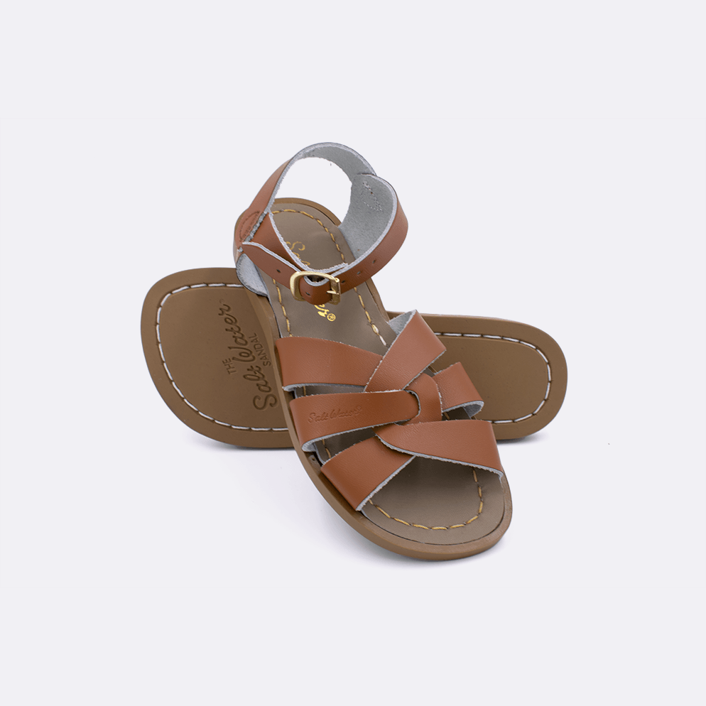 Two tan little kid sized 800 Original style sandals.  One standing with the sole facing the camera. The second is laying diagonally over the top left edge of the sole.