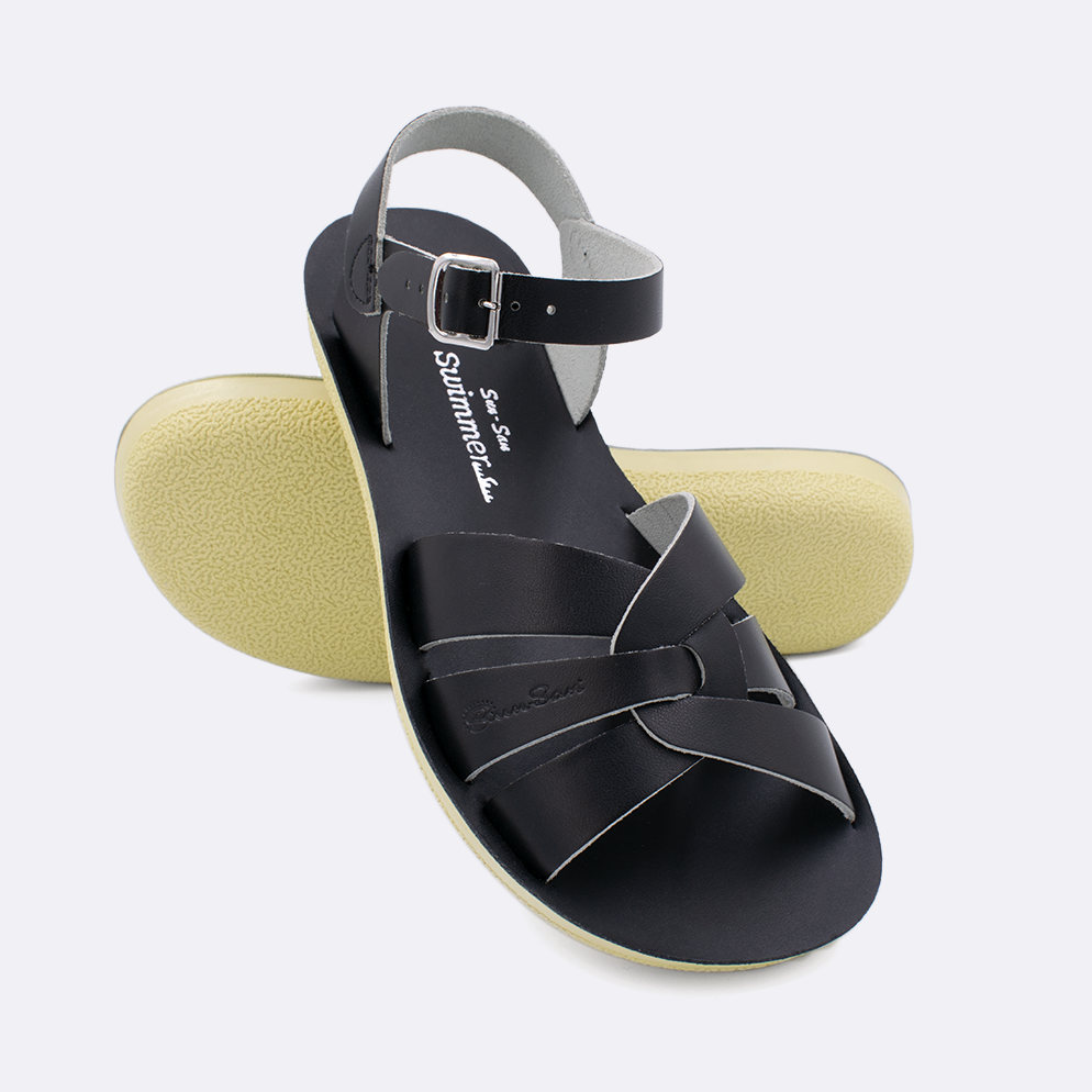 Two women's sized 8000 Swimmer style sandals with black straps and black insoles.  One standing with the sole facing the camera. The second is laying diagonally over the top left edge of the sole.